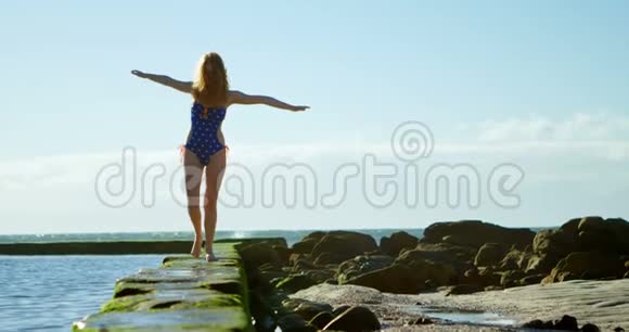 女子在沙滩上伸臂行走视频的预览图