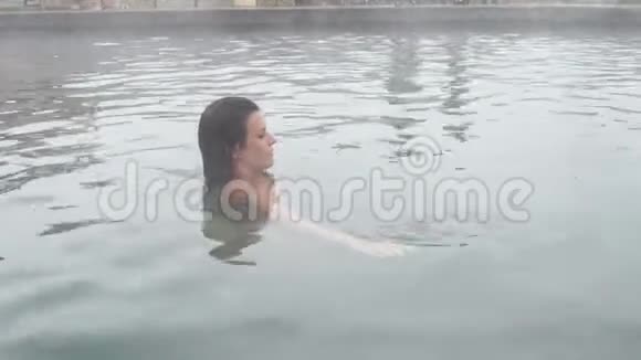 地热温泉女人在温泉池里放松女孩享受沐浴欧泊盆地与温暖的矿泉水25fps视频的预览图