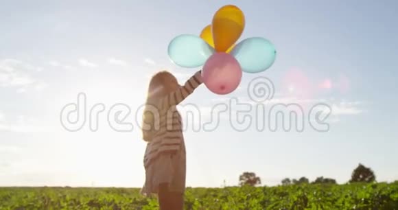 小女孩手里拿着气球在户外慢动作跳舞视频的预览图
