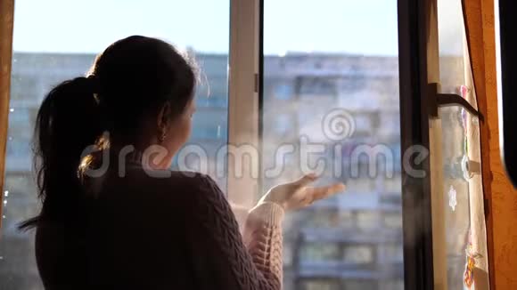 寒冷的冬天女孩打开窗户在寒冷的空气中呼吸视频的预览图
