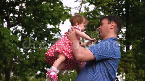 快乐的爸爸抱着他心爱的女儿在她的怀里亲吻她的脸颊和微笑视频的预览图