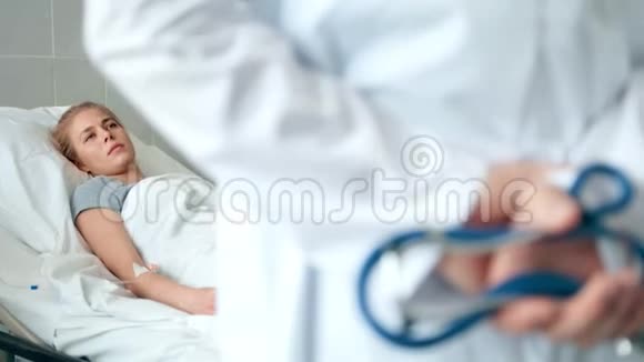 医生拿着听诊器站在医院的房间里关注病人视频的预览图