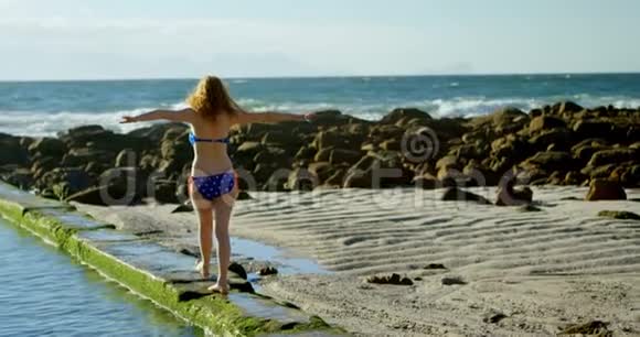 女子在沙滩上伸臂行走视频的预览图