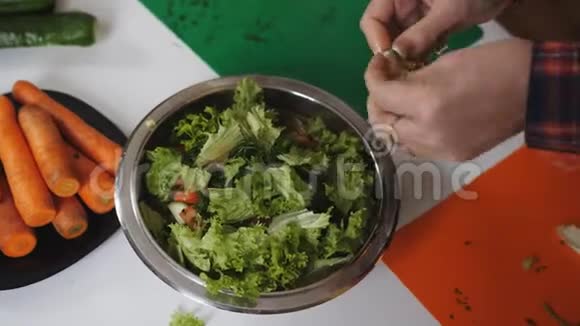 两个女人在碗里切生菜蔬菜沙拉的准备视频的预览图