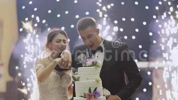 新娘和新郎在结婚那天切蛋糕互相喂饭开怀大笑视频的预览图