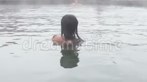 地热温泉女人在温泉池里放松女孩享受沐浴在温暖的矿泉水30fps的露天盆地视频的预览图