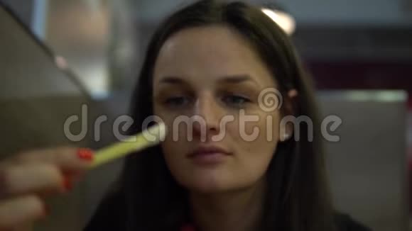 在餐馆里吃法国薯条的年轻女人脸部特写视频的预览图