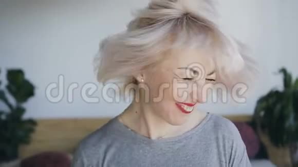 一个天生美丽的女人留着白色的头发和红色的口红笑着向左和向右挥动她的头她视频的预览图