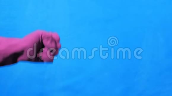 干净的手在蓝色背景上的紫色橡胶手套石头纸剪刀视频的预览图