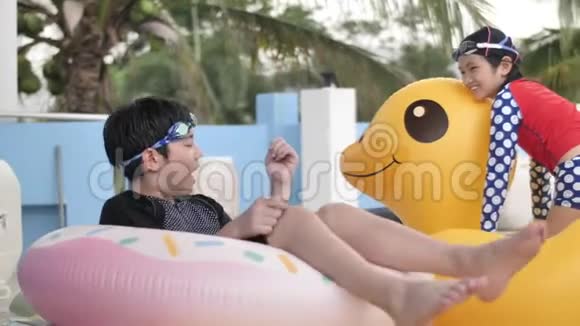亚洲快乐的兄妹在游泳池里玩着笑脸视频的预览图