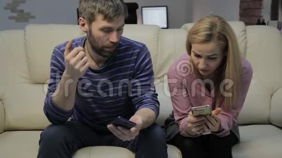 妻子和丈夫在看智能手机时交流家庭生活概念视频的预览图