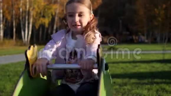 小可爱的女孩在公园的操场上荡秋千玩乐视频的预览图