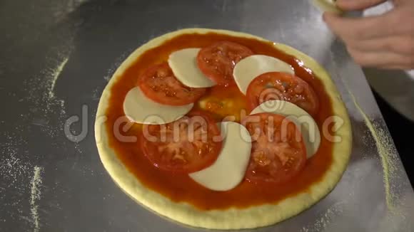 手工厨师把西红柿和奶酪放在披萨的特写中视频的预览图