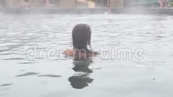 地热温泉女人在温泉池里放松女孩享受沐浴欧泊盆地与温暖的矿泉水25fps视频的预览图