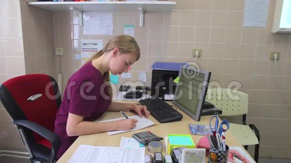 年轻的女医生在桌面上写字视频的预览图