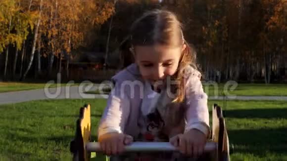 小可爱的女孩在公园的操场上荡秋千玩乐视频的预览图
