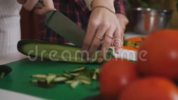两个女人一起在厨房做饭特写镜头雌性手切蔬菜做新鲜沙拉家庭烹饪视频的预览图