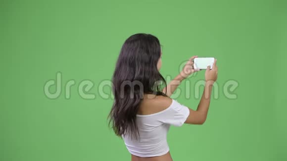 年轻多民族妇女用电话拍照的后景视频的预览图