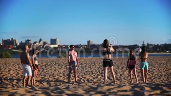 一群年轻漂亮的人在河边打沙滩排球视频的预览图