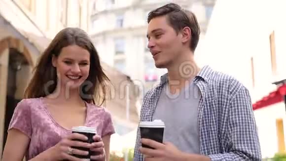 年轻人喝咖啡在城市大街散步视频的预览图