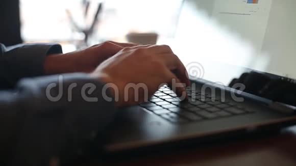 相机在自由职业者手在笔记本电脑键盘上慢动作的滑动在办公室工作的商人视频的预览图