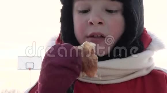 一个小孩子正在冬天的寒冷中吃饭视频的预览图