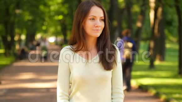 一个悲伤的女人独自站在夏日公园的肖像视频的预览图