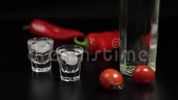樱桃番茄卷两杯伏特加黑色背景视频的预览图