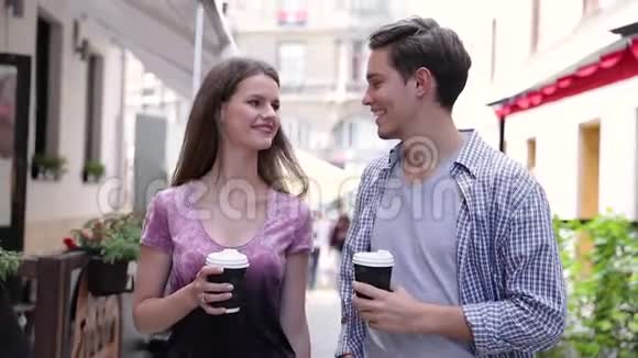 年轻人喝咖啡在城市大街散步视频的预览图