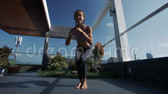 女人改变瑜伽姿势在屋顶休息室天空视频的预览图