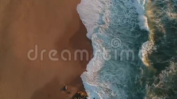 在葡萄牙的海滩上无人机飞过海浪留下沙滩上的脚印视频的预览图