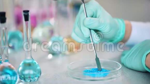 科学家用手在玻璃皿上准备粉末以便在实验室进行一些研究视频的预览图