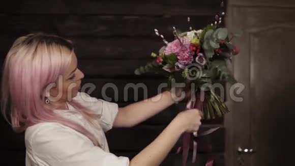 一个粉红色头发的女孩手里拿着各种各样的花在她面前花束上装饰着晃荡视频的预览图