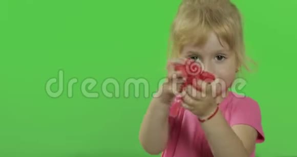 快乐的小女孩在色度键背景上玩塑料视频的预览图