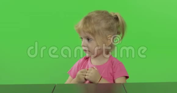 快乐的小女孩在色度键背景上玩塑料视频的预览图
