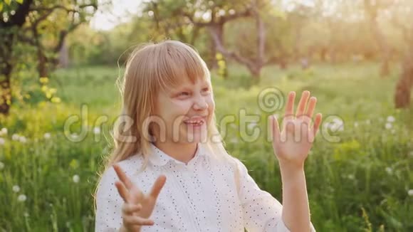 无忧无虑的女孩正兴高采烈地抓住肥皂泡在春天的花园里散步视频的预览图