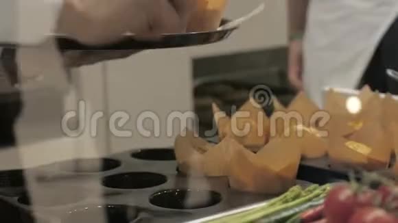 手面包师在面包店用纸包装盘松饼视频的预览图
