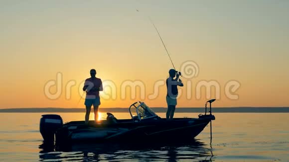 日出时两名男性渔民的捕鱼过程视频的预览图