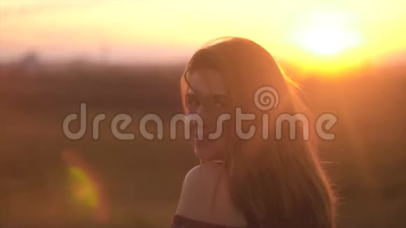 女人享受温暖的夏天日落夕阳下美丽的女人视频的预览图