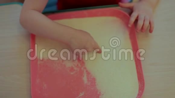 小孩用手指在沙子上视频的预览图
