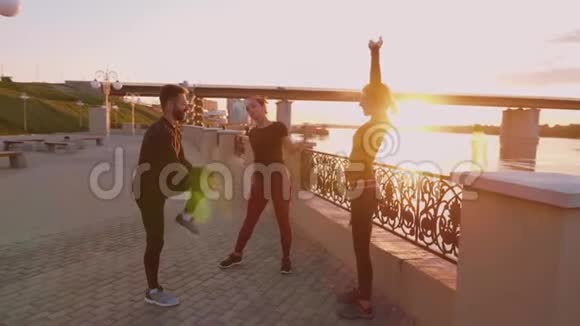 有人在健身男人和女人在美丽的夕阳下做伸展运动视频的预览图