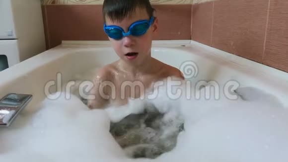 男孩67年在浴室里溢出水坐在浴缸里泡沫视频的预览图
