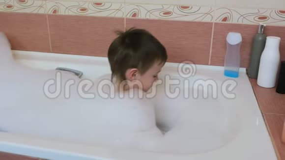 孩子67在浴缸里玩白色泡沫带上泡沫戴上他的头视频的预览图
