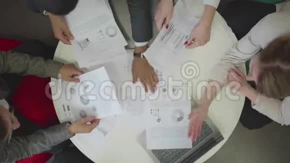 人们拿着文件和笔记本坐在桌子旁视频的预览图