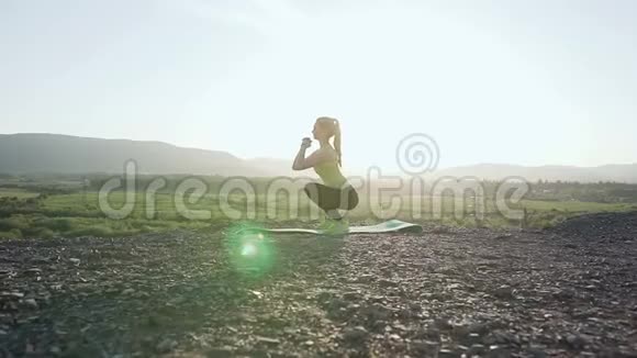 年轻美丽的运动女性日出时在山顶上做运动晨练健康视频的预览图