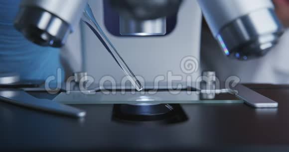 技师把吸管滴在玻璃玻片上以便在显微镜下进一步检查视频的预览图