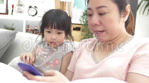 快乐的亚洲家庭母女在电话里看着微笑着扩展视频的预览图