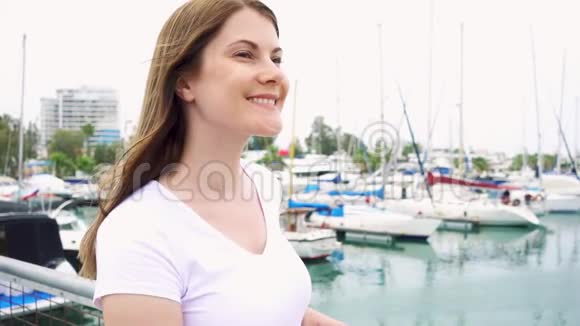 年轻女子独自站在码头的肖像从海上吹来的风慢慢地吹着女性的头发视频的预览图