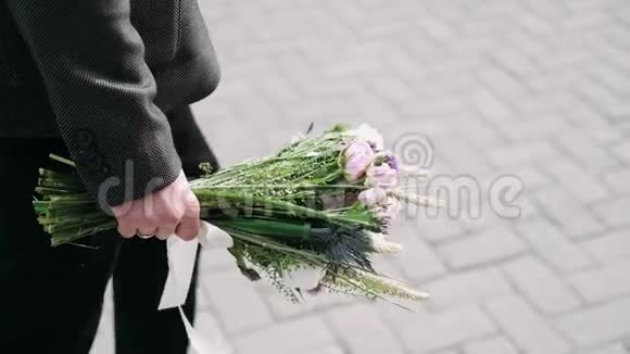 年轻人走在街上手里拿着一束花关门视频的预览图