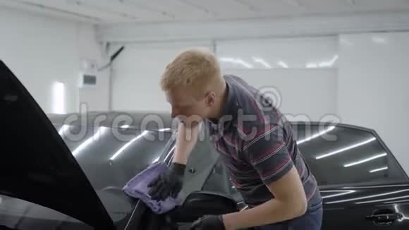 洗车机用软布擦拭清洗后的黑色汽车在汽车车间的一个房间里抛光视频的预览图